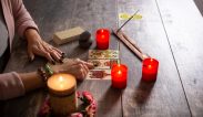 fortune-teller-reading-future-by-tarot-cards-on-rustic-table-scaled.jpg